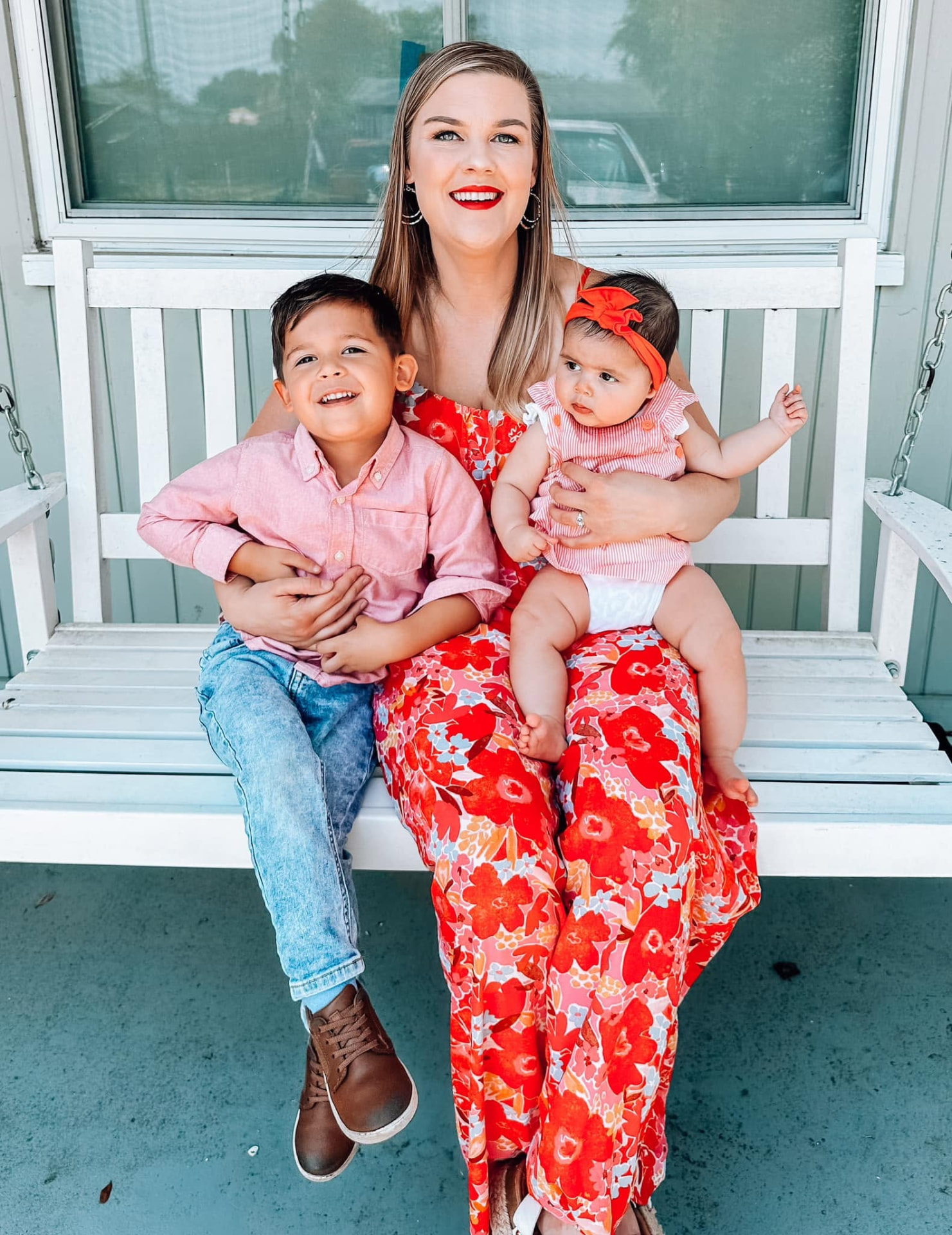 Bethany sitting on a porch swing with her two children